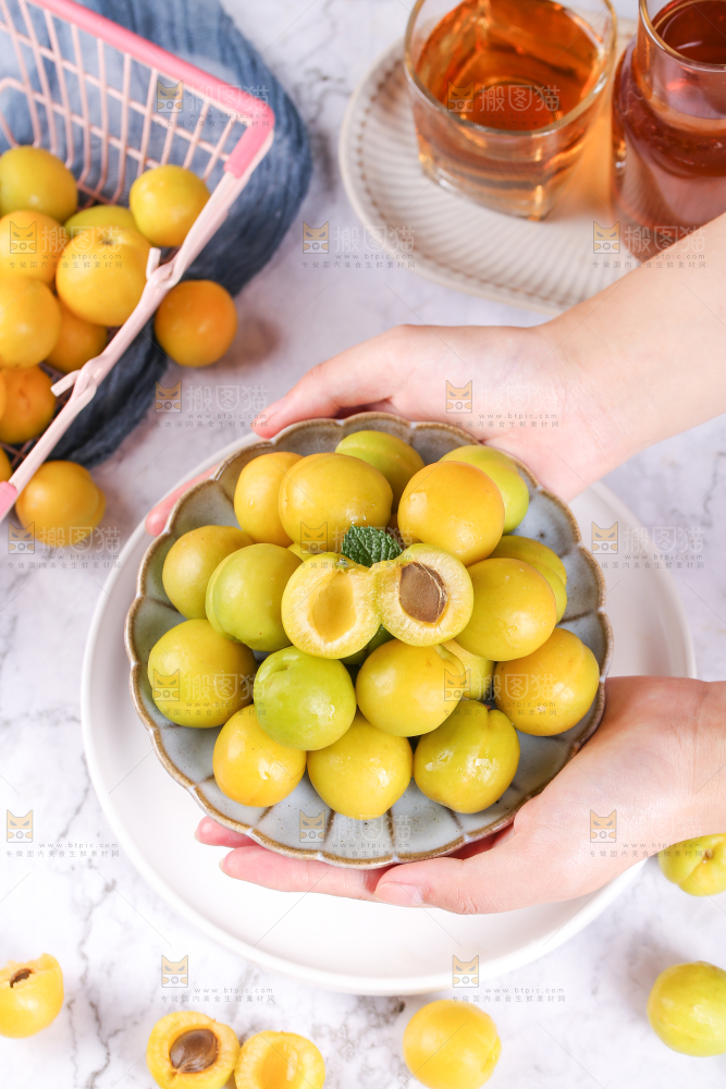 手上捧着一盘小白杏