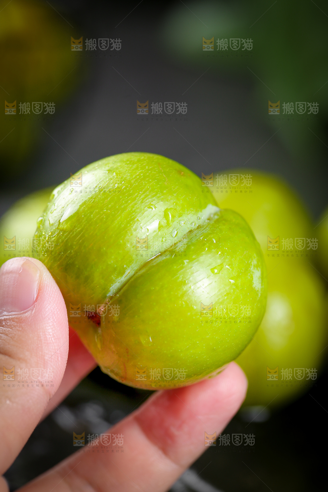 手上拿着蜂糖李