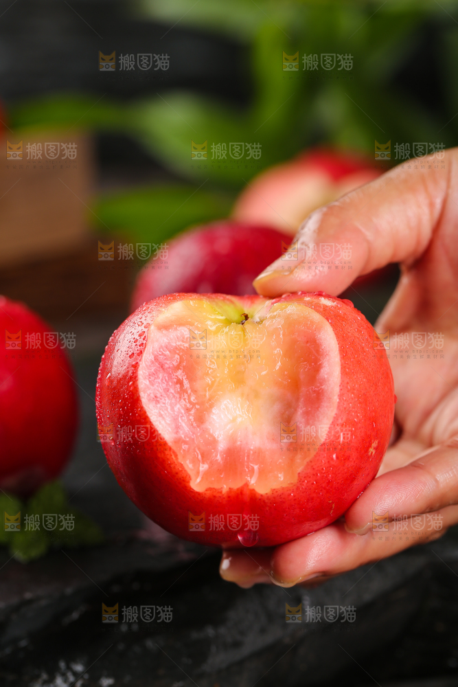 手上拿着红肉油桃