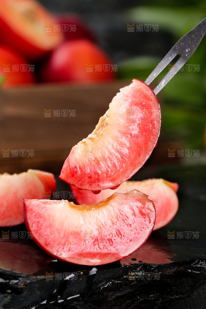 叉子上叉着的红肉油桃