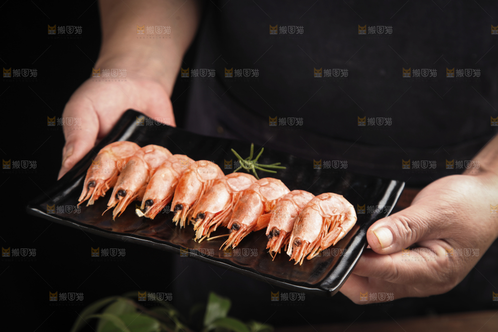 手上端着一盘甜虾