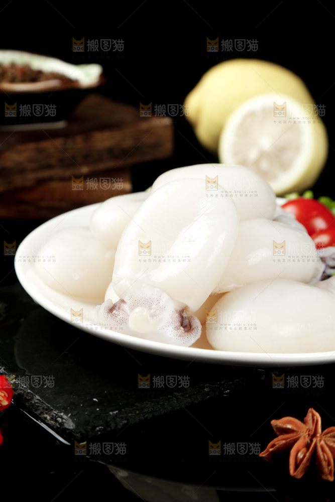 黑底上摆放着一盘新鲜墨鱼仔