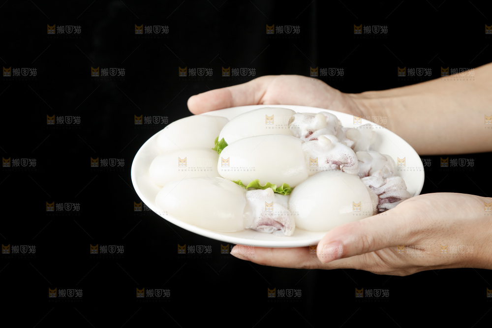 手里端着一盘墨鱼仔