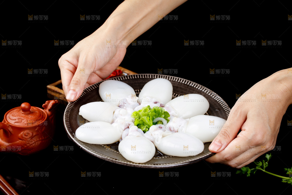 手里端着一盘小墨鱼