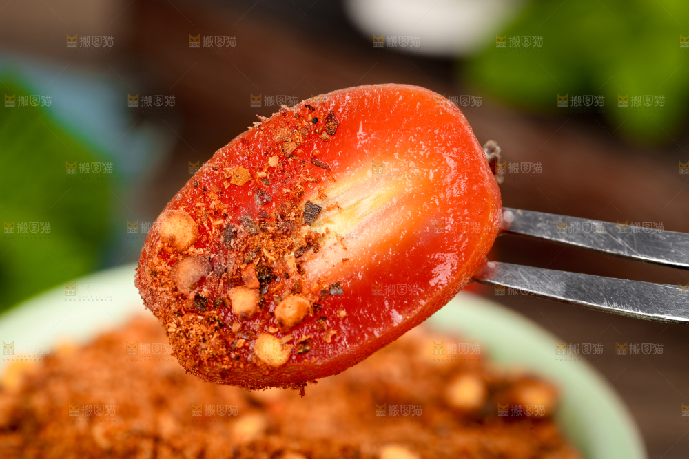 叉子插着蘸辣椒粉的羊奶果