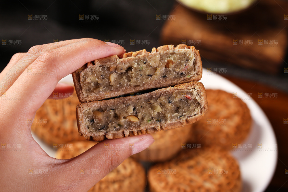 手拿着掰开的荞麦五仁月饼