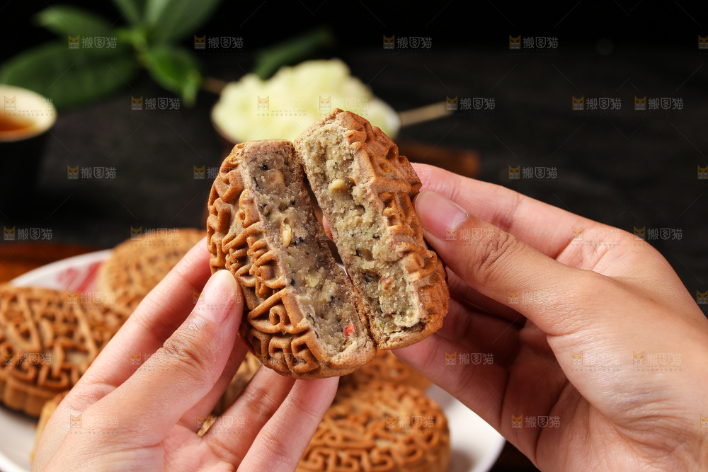 手拿着掰开的荞麦五仁月饼