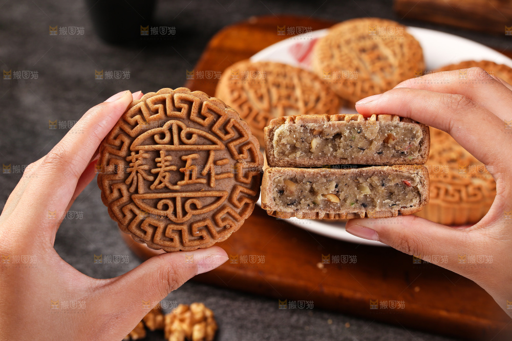 手拿着掰开的荞麦五仁月饼