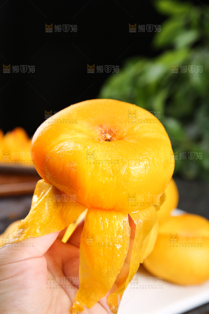 手拿着剥皮的黄蟠桃