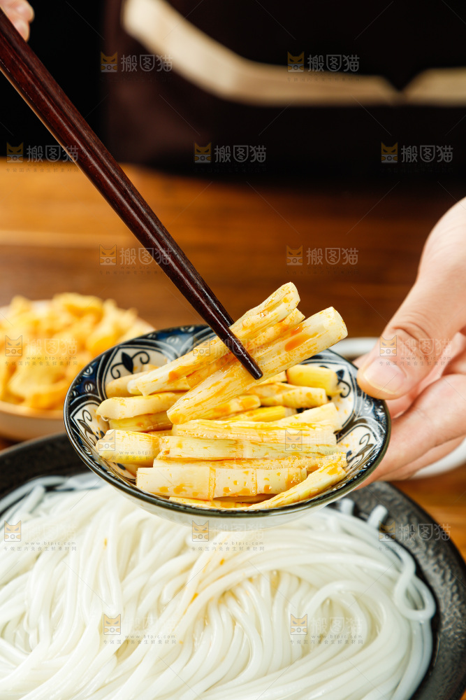 筷子夹着碟子里的酸笋