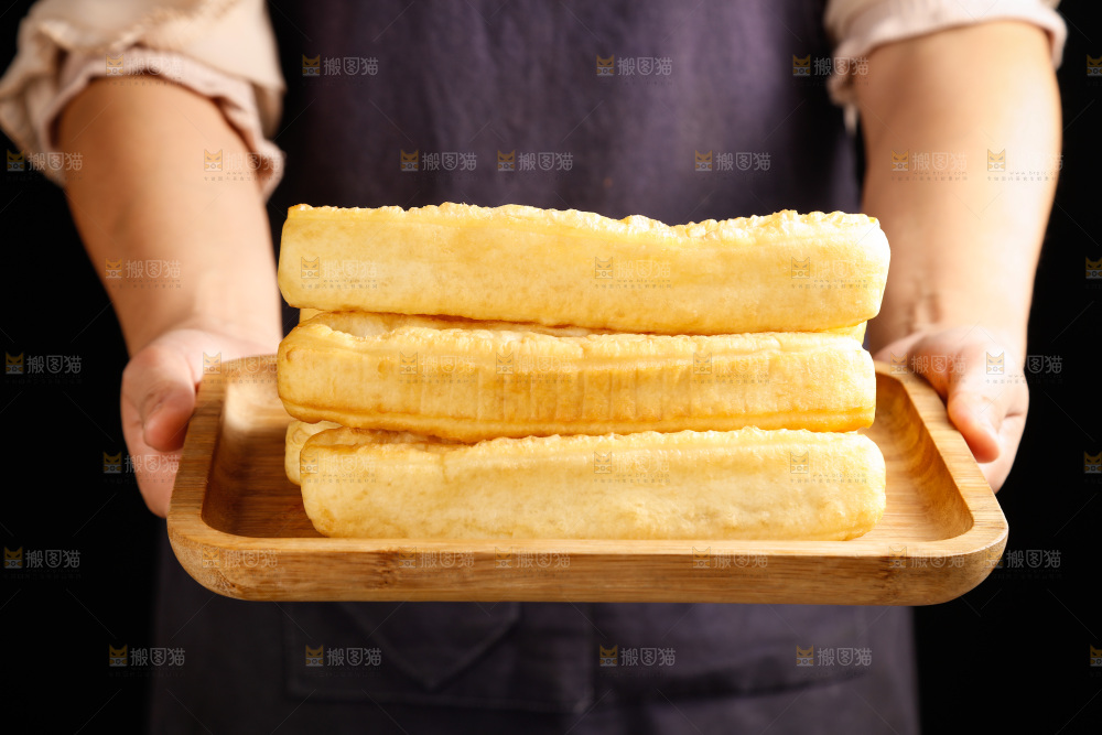 手里端着一盘油条