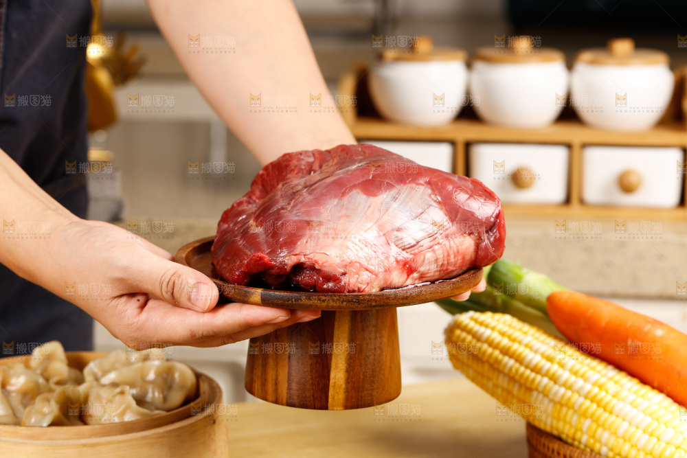 手端着一盘生牛肉