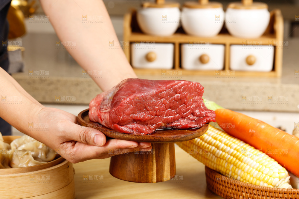 手端着一盘生牛肉