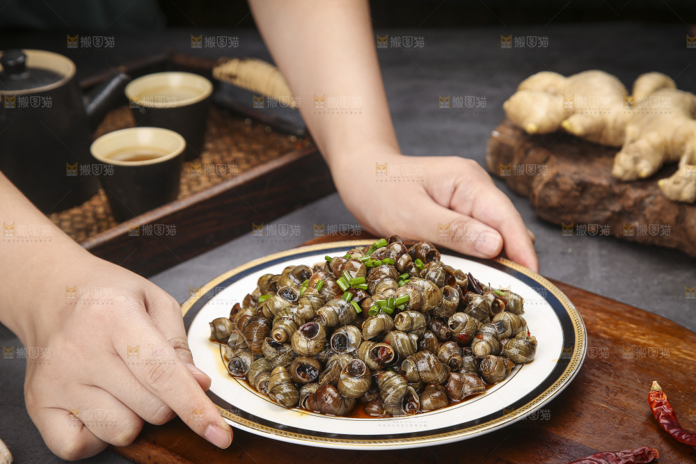 手端着一盘香辣田螺