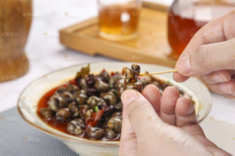 手里拿着牙签挑田螺肉