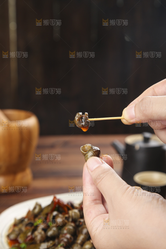 手里拿着牙签挑田螺肉