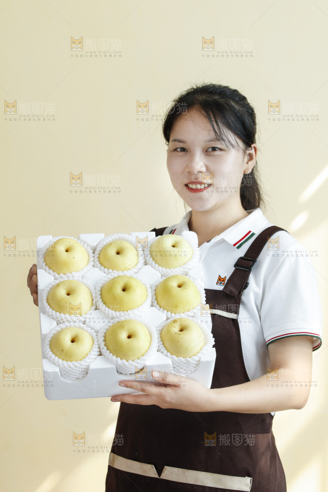 女孩手里端着一箱皇冠梨