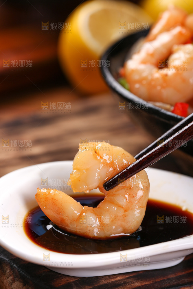 筷子上夹着蘸酱的虾仁