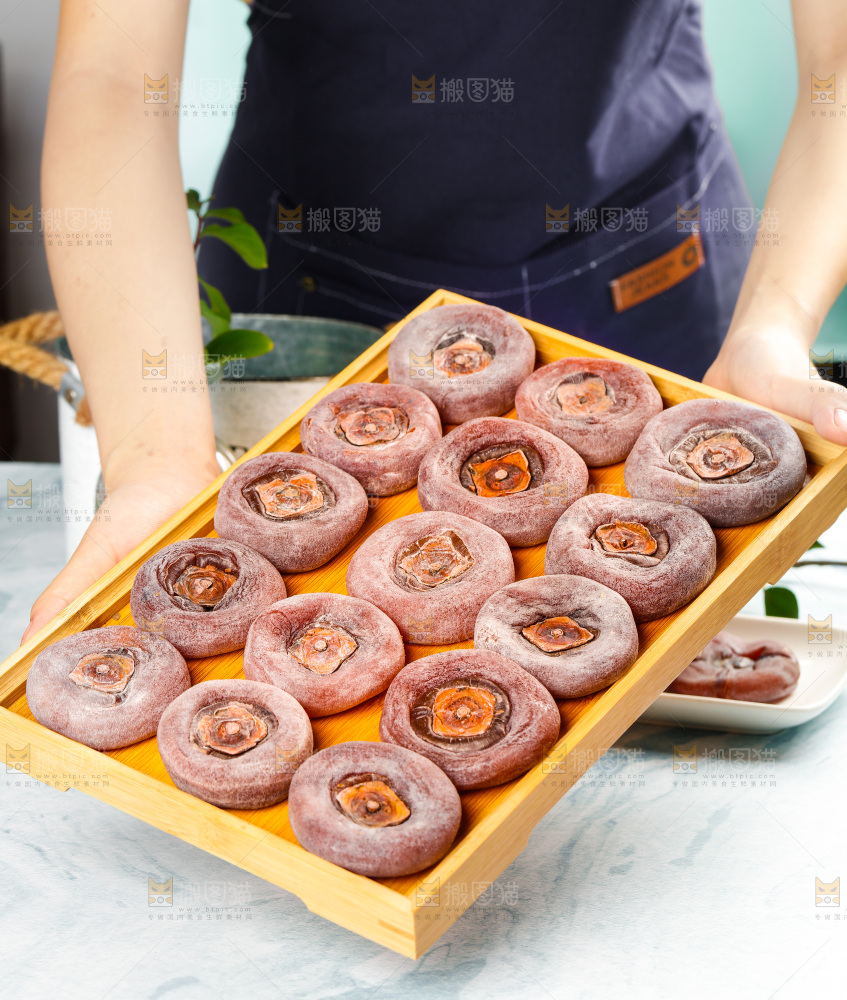 手端着一盘圆柿饼