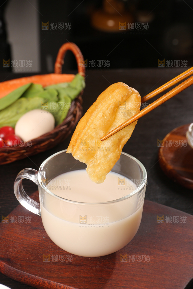 筷子夹着豆浆蘸油条