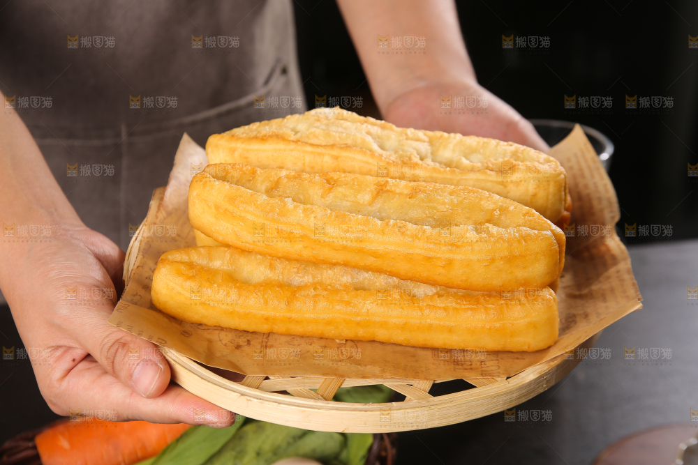 手里端着一盘油条