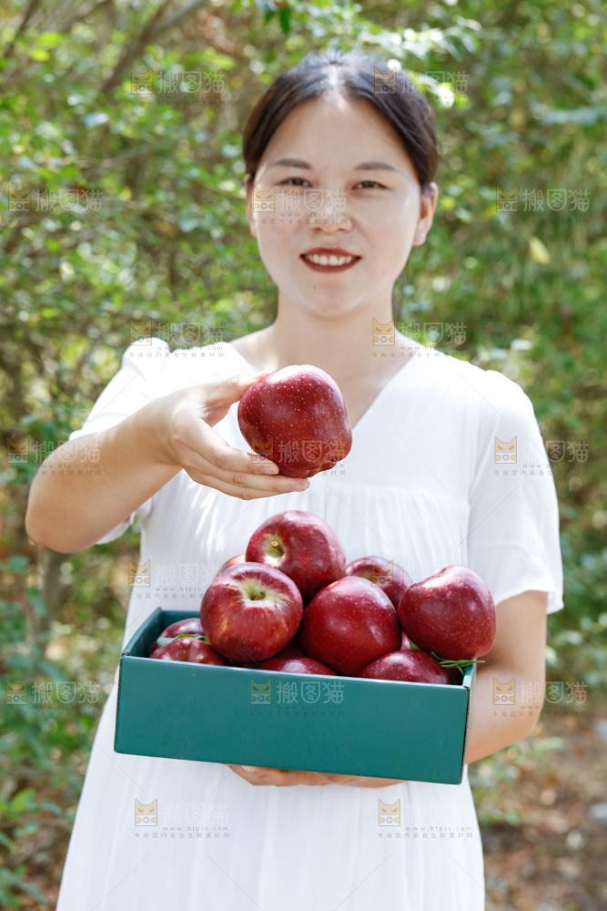 女孩手里拿着一盒花牛苹果