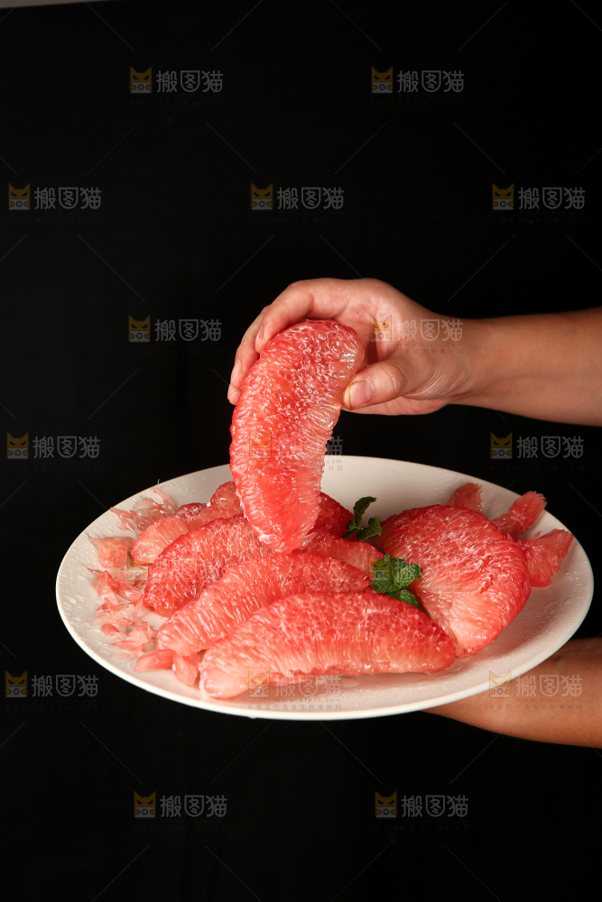 手里端着一盘红心蜜柚果肉