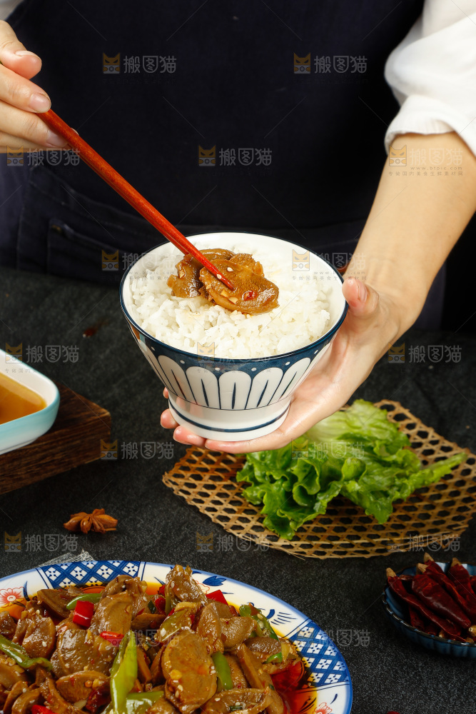 手里端着一碗米饭和筷子上夹着猪宝