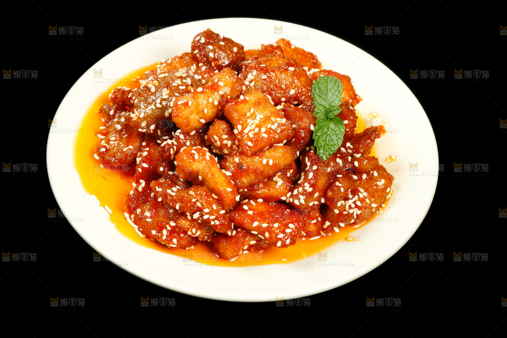 一盘糖醋里脊肉摆在黑底上