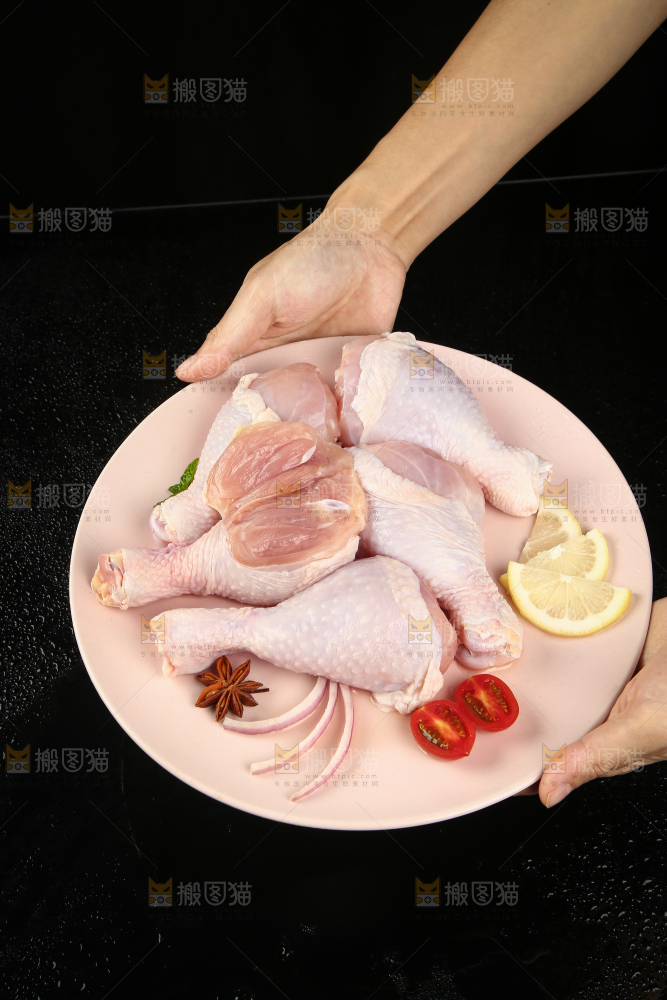 手里端着一盘生鸡腿