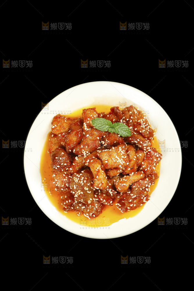 一盘糖醋里脊肉摆在黑底上