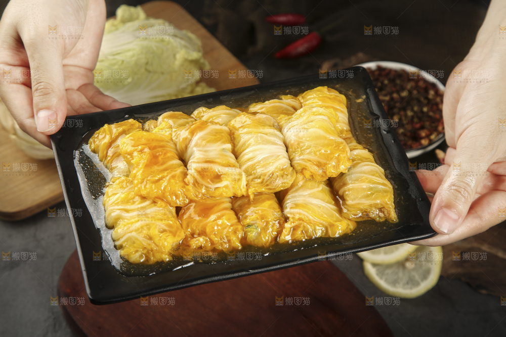 手里端着一盘白菜酿肉卷