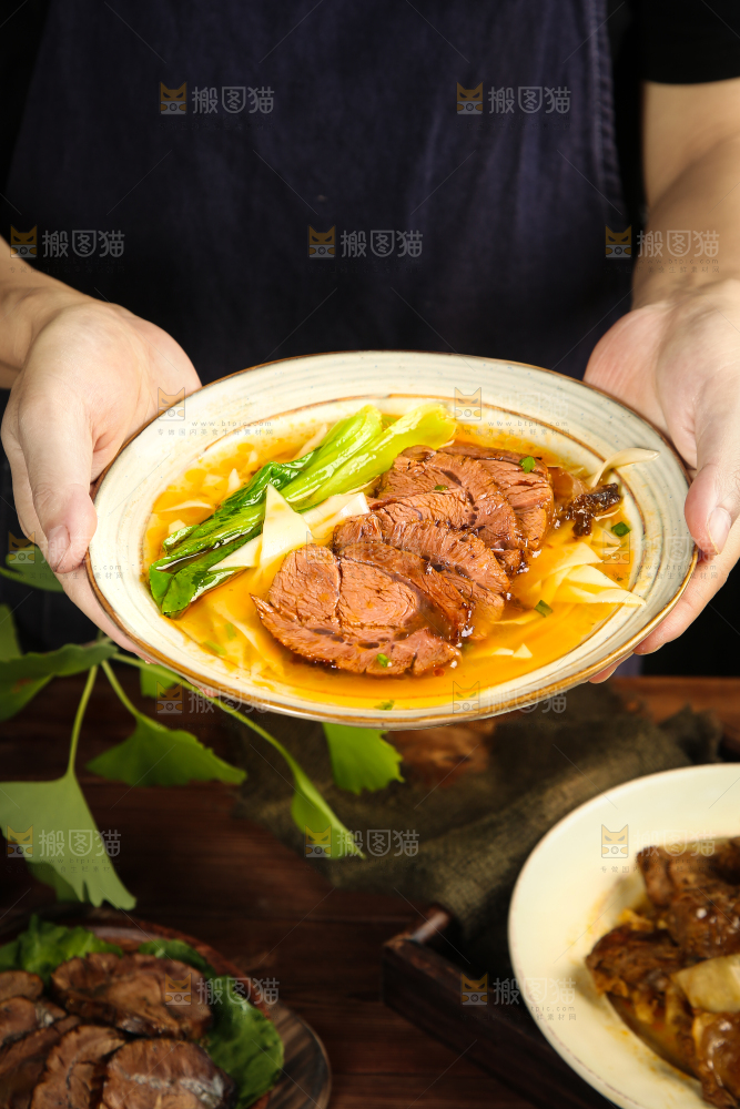 手里端着一碗刀削牛肉面