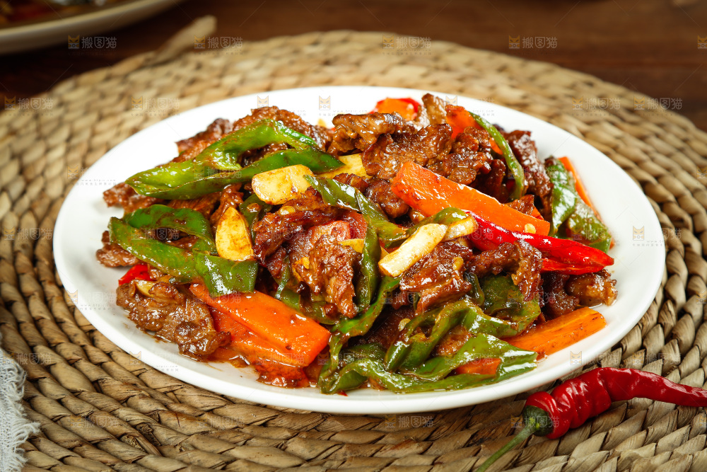 垫子上摆放着一盘青椒炒牛肉