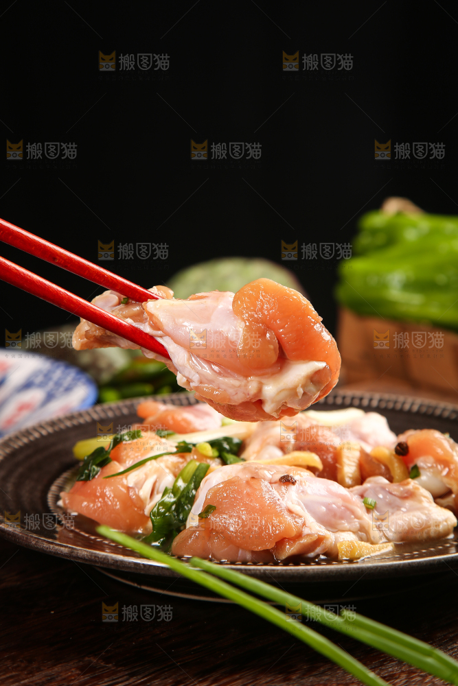 筷子夹着腌制的鸡腿