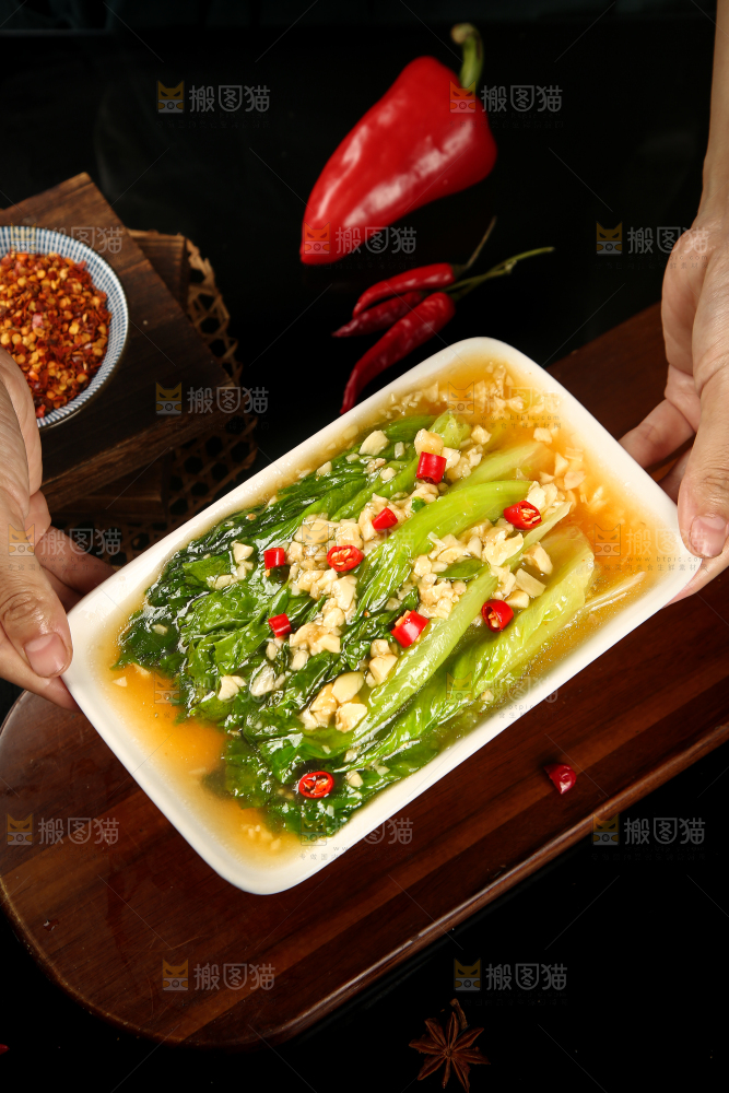 手里端着一盘蒜蓉生菜