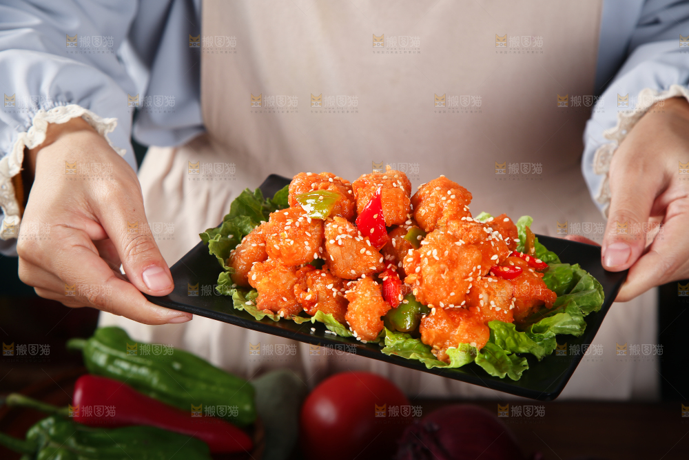 手里端着一盘糖醋咕噜肉