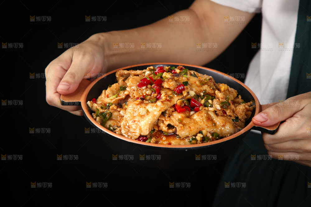 手里端着一盘香辣水煮肉片