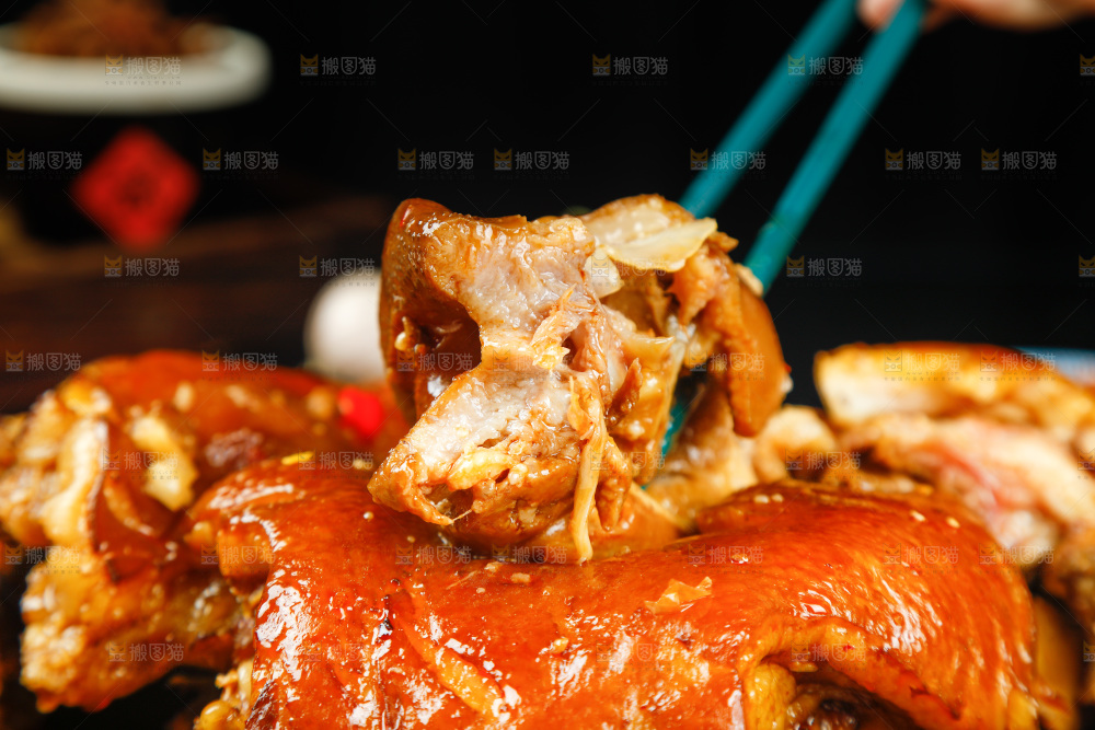 筷子上夹着卤味猪头肉