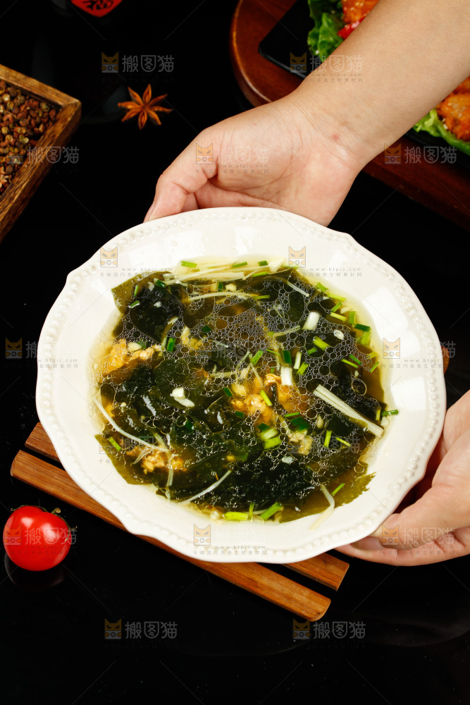 手里端着一盘裙带菜汤