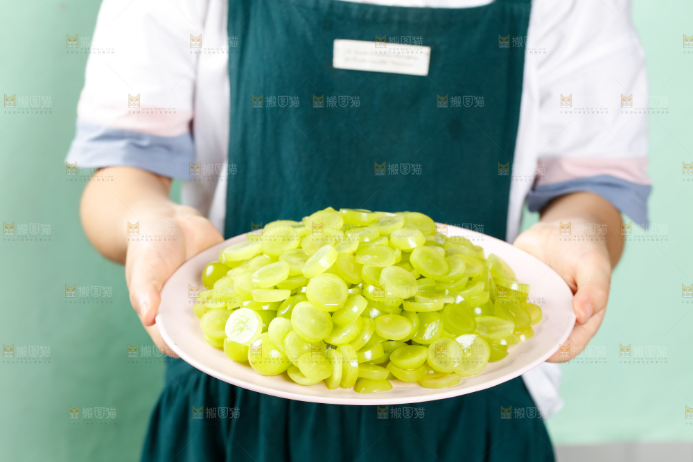 手里端着一盘无籽葡萄