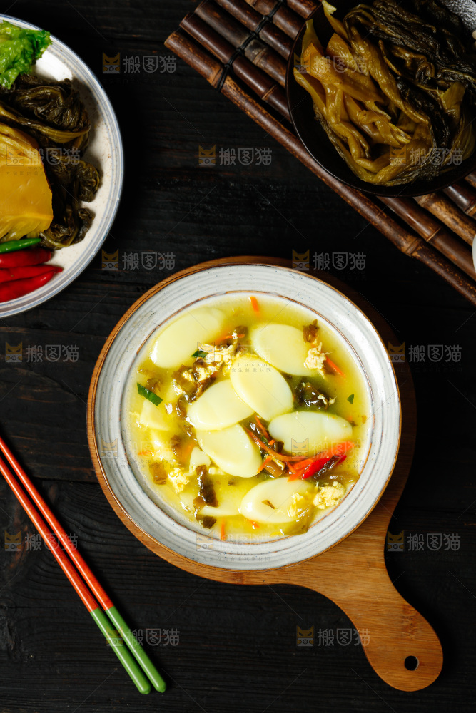木板上放着一碗酸菜年糕汤