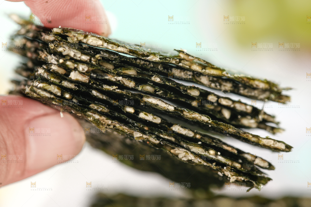 手里拿着芝麻夹心海苔