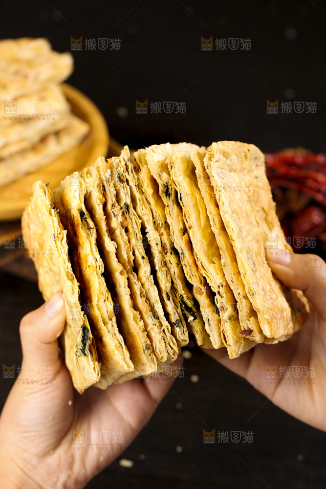 手里拿着梅干菜锅盔