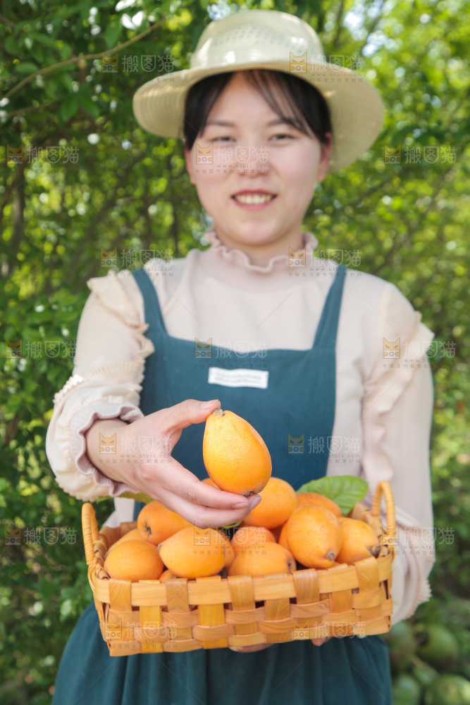 女孩手里端着一篮新鲜枇杷