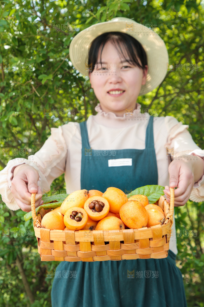 女孩手里端着一篮新鲜枇杷