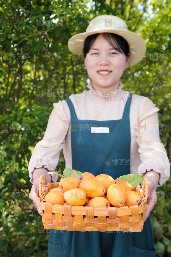 女孩手里端着一篮新鲜枇杷
