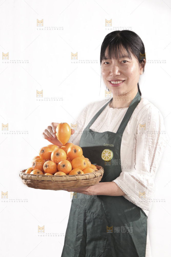 女人手里端着一篮枇杷