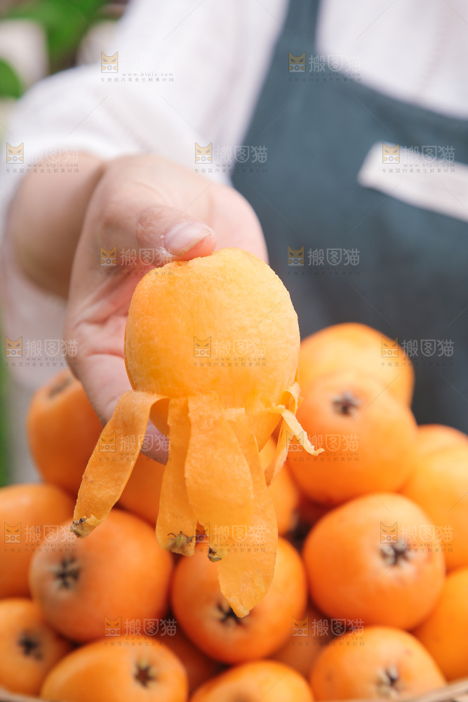 手里拿着新鲜枇杷