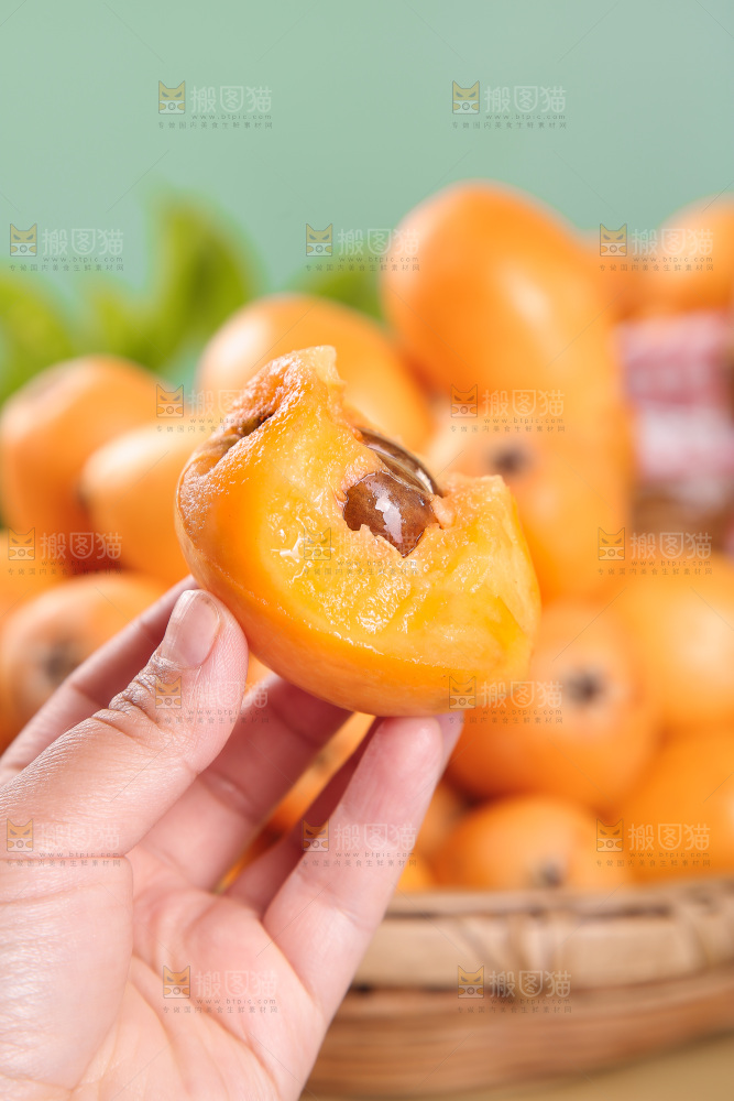 手里拿着新鲜枇杷